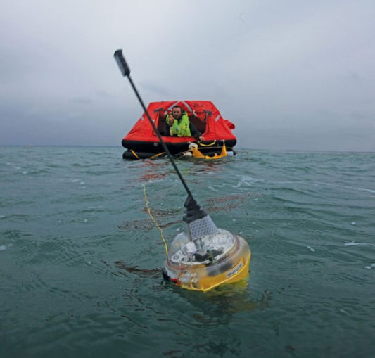 TeamO now has manoverboard safety equipment. Image shows a manoverboard device in the water with a life raft in the background